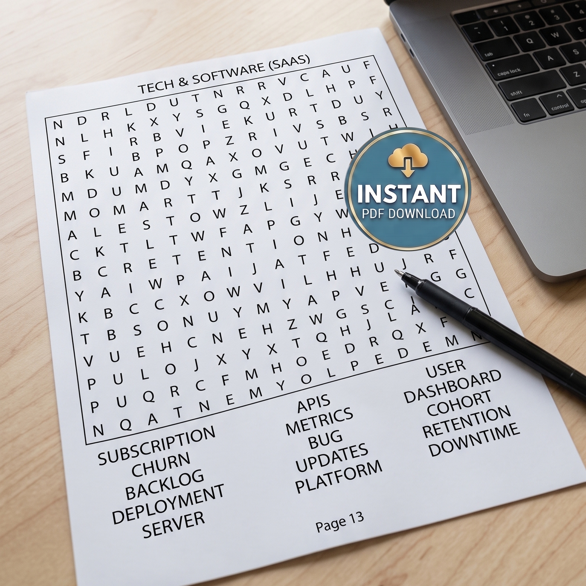 The page from a business and money word search book titled Tech & Software (SAAS) laying on a desk with a pen next to a laptop.